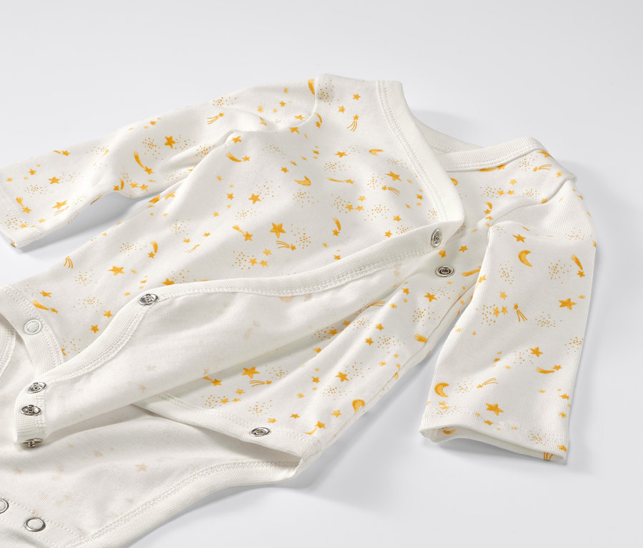 Gros plan sur un lot de 5 bodys évolutifs pour bébé à motif étoile.