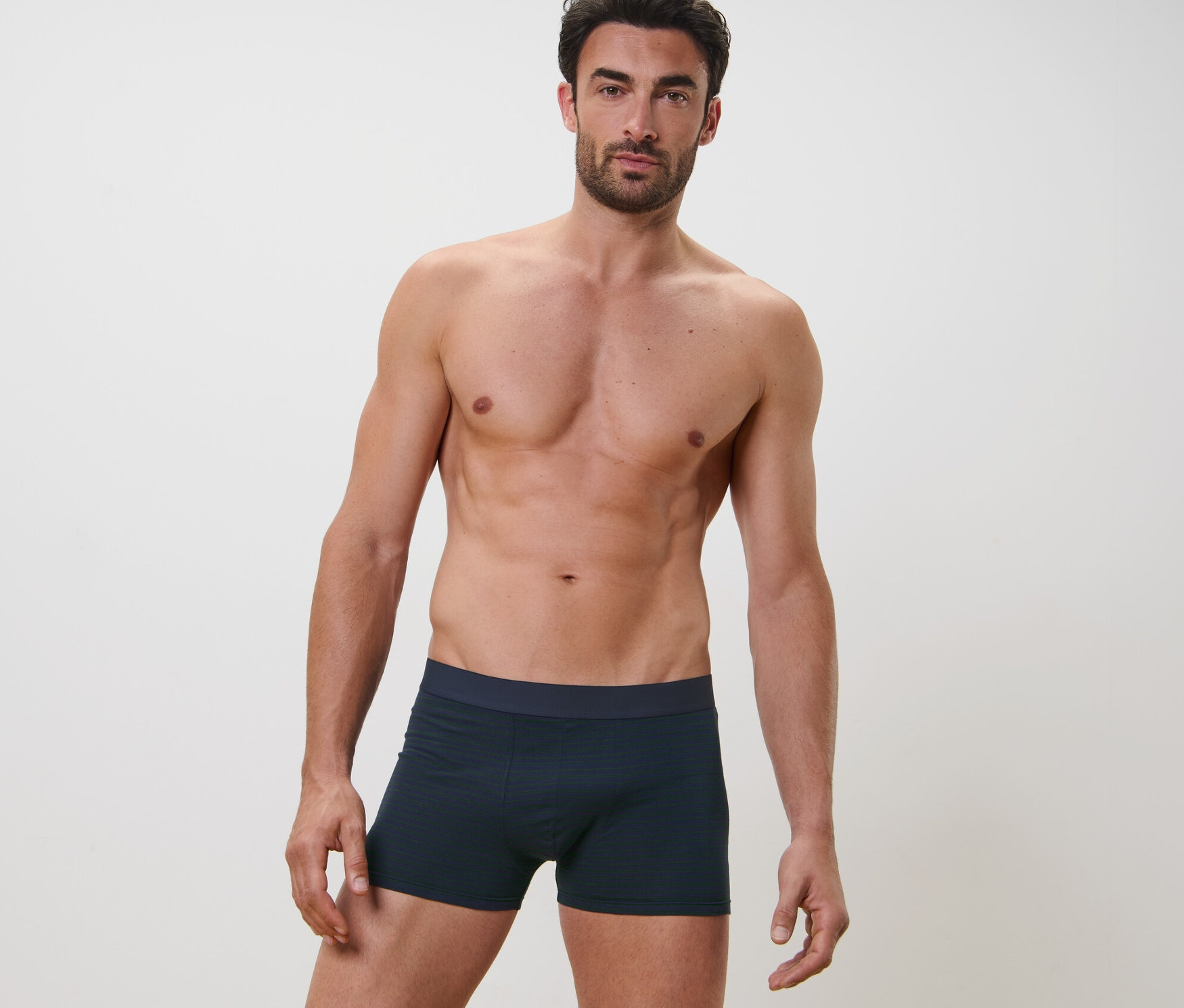 Un homme pose sur l'image et porte 2 Boxers.