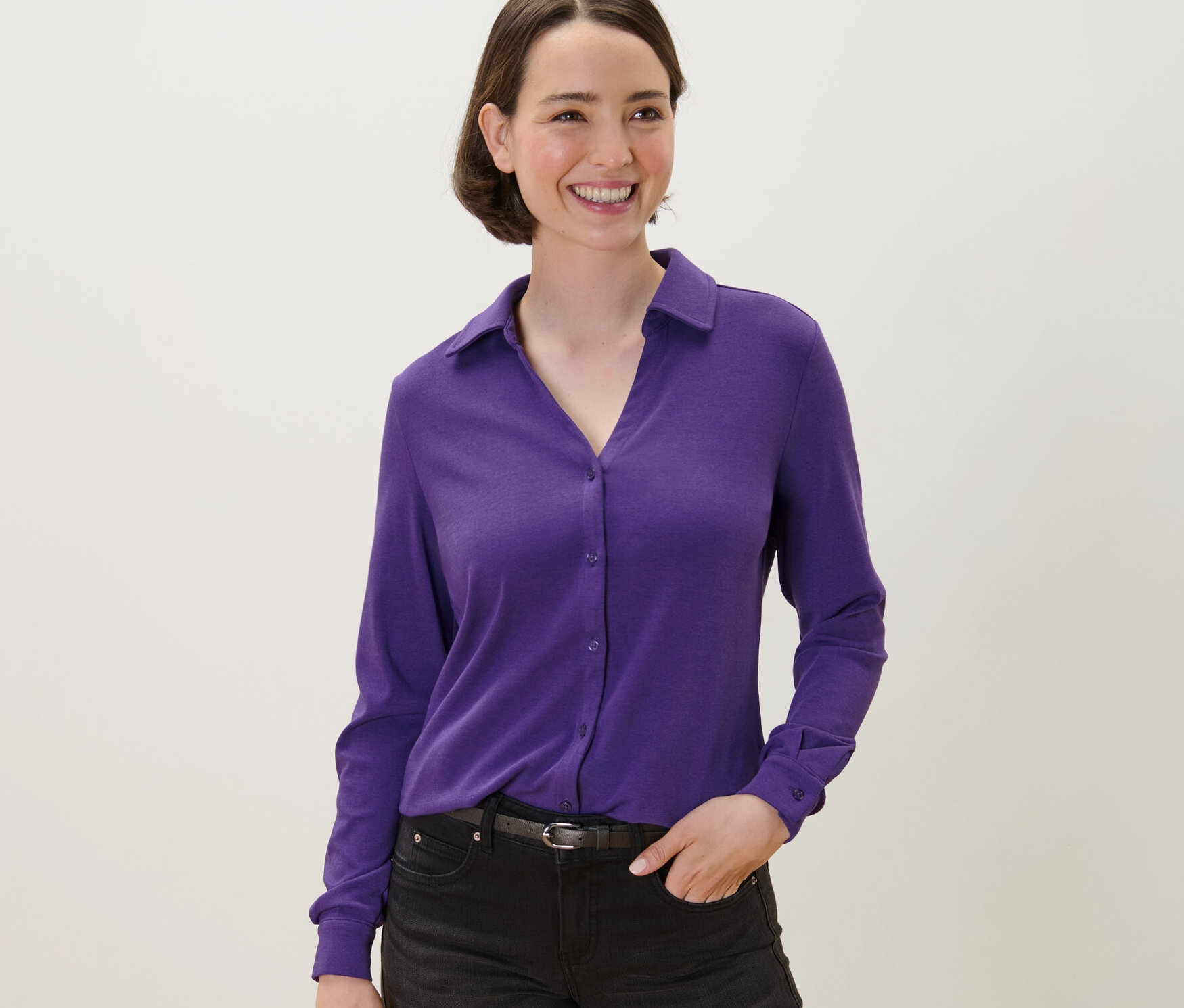 Femme portant une blouse violette avec patte de boutonnage.