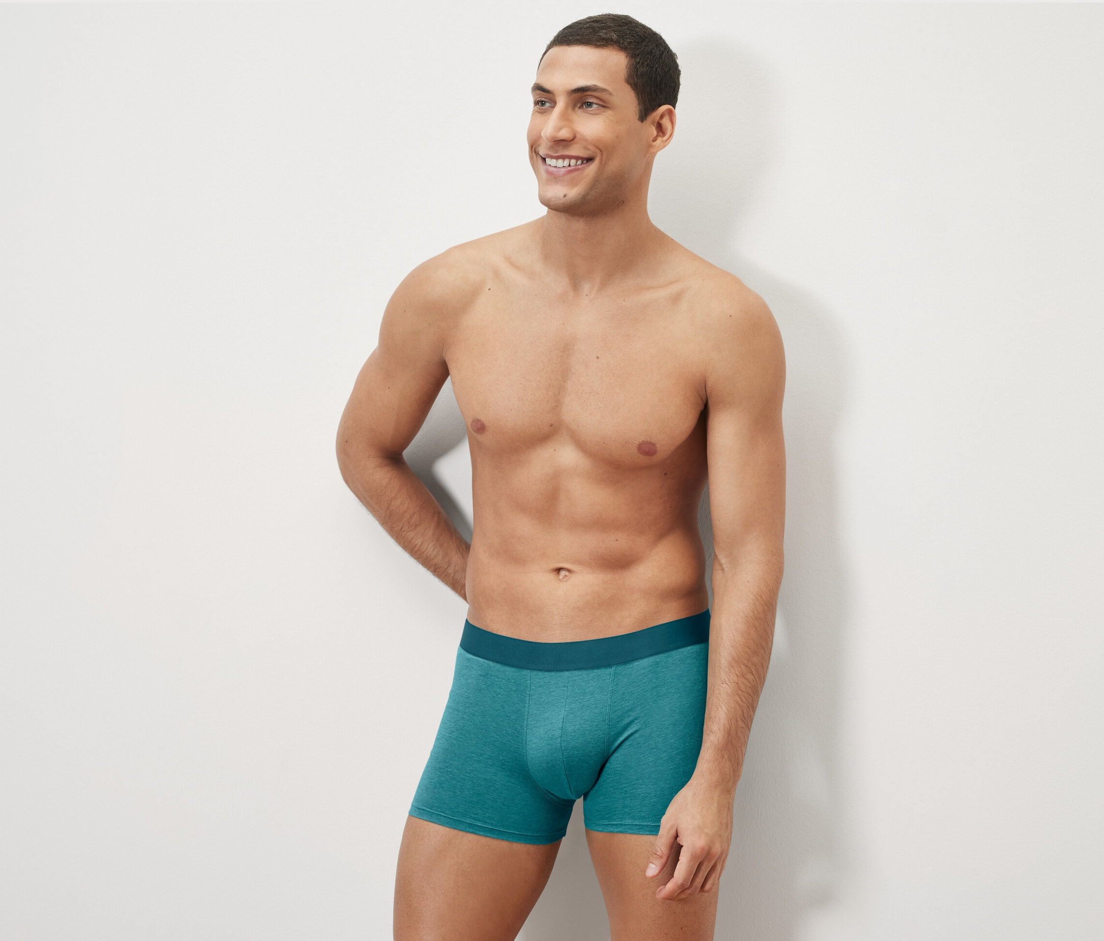 Un homme pose en portant des 4 boxers, imprimé intégral verts.