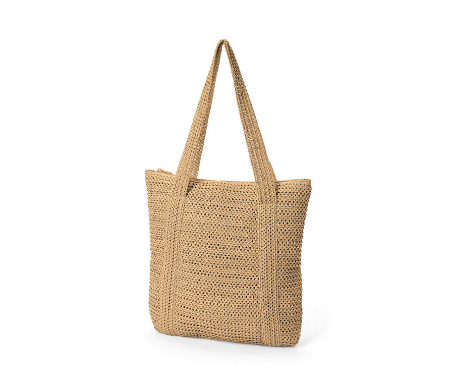 Gros plan d'un cabas aspect raphia sur fond blanc.