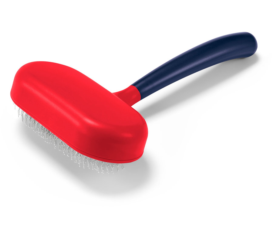 Une brosse pour animaux rouge avec un manche bleu posée sur un fond blanc.