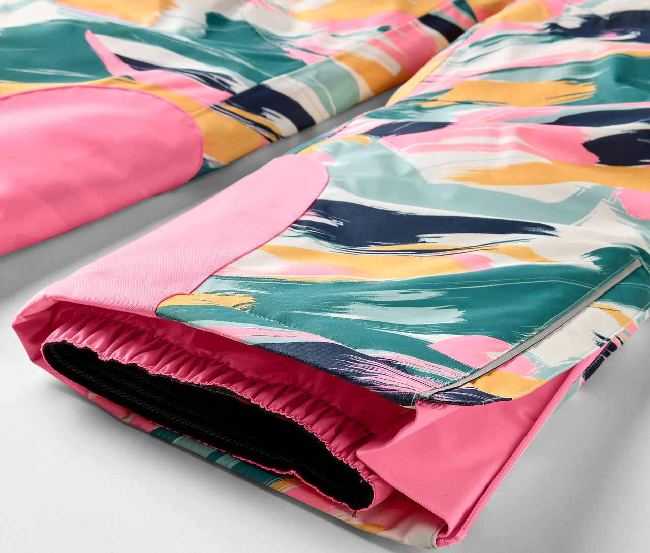 Détail d'un pantalon coloré avec des détails roses.