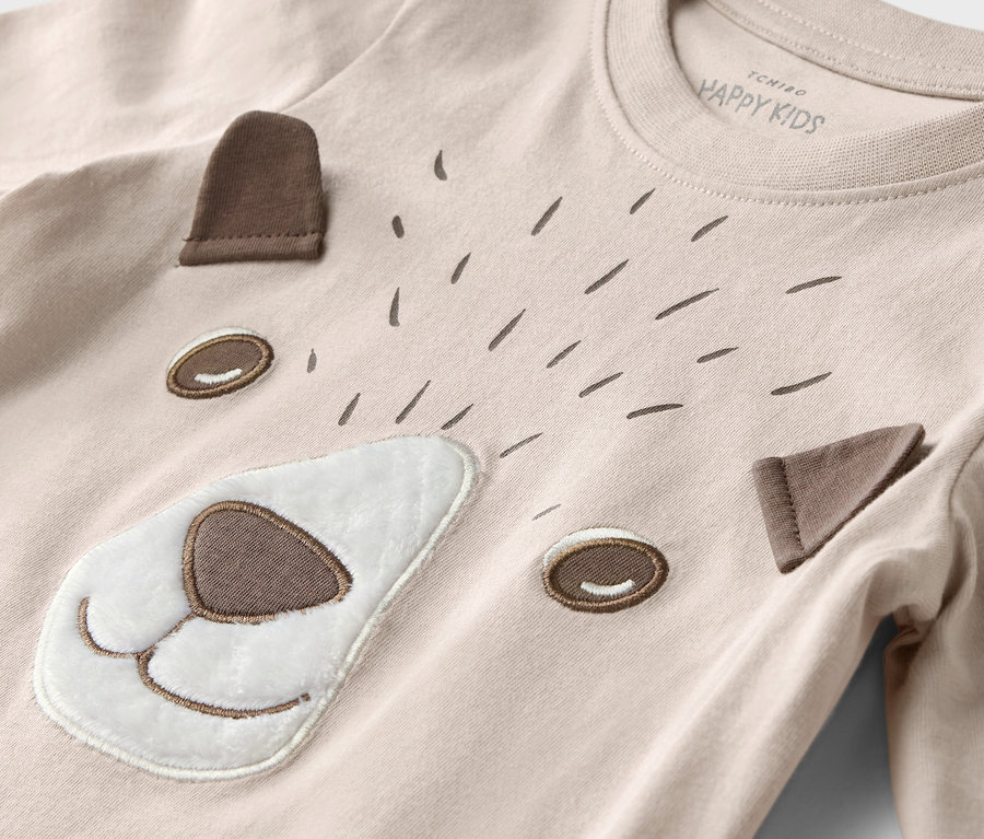 Gros plan sur un t-shirt à manches longues pour enfants avec un motif de visage d'ours et d'animaux de la forêt.