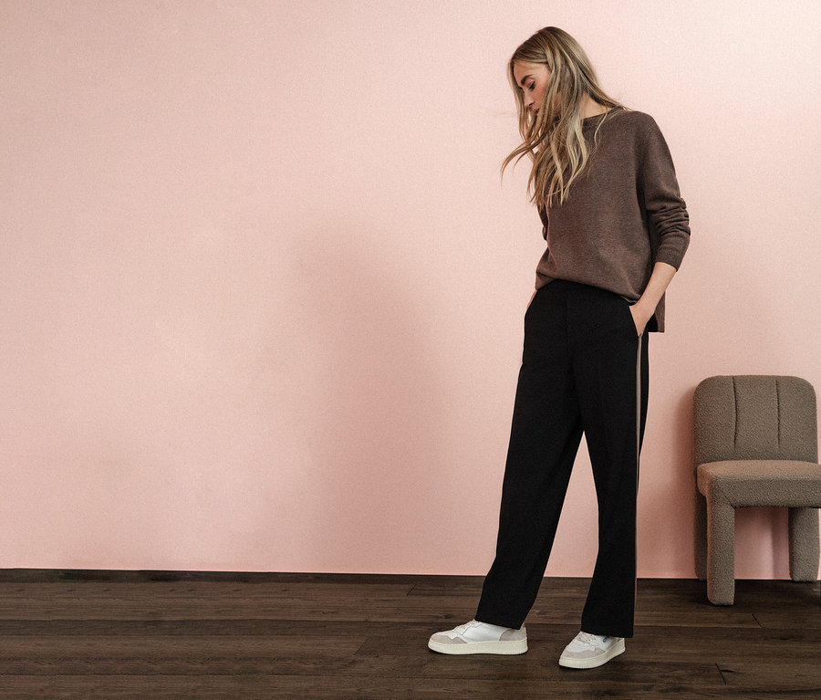 Femme portant un pull marron et un pantalon noir Straight Leg avec galon Street One, les mains dans les poches.