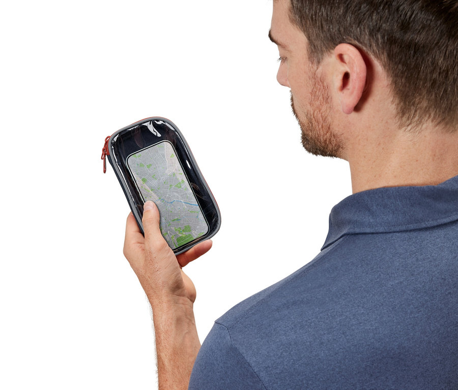 Un homme regarde une pochette multifonction avec fenêtre transparente.