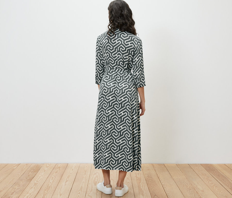 Femme vue de dos portant une robe chemise imprimée.