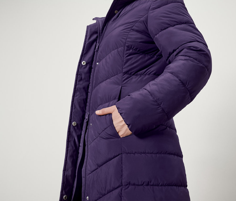 Gros plan sur une doudoune violette avec une main dans la poche.