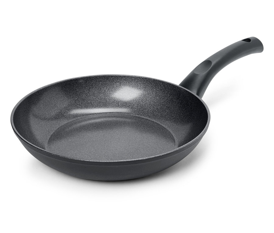 Gros plan d'une poêle à frire noire avec une surface texturée sur un fond blanc.