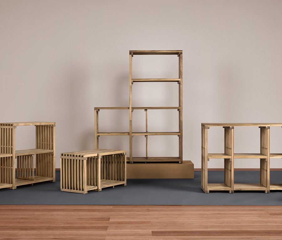 Quatre étagères en bois de différentes tailles sur un tapis gris sur un plancher en bois.