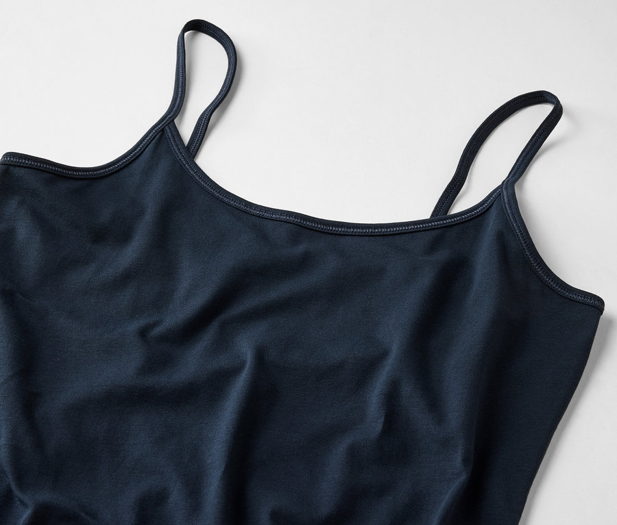 Gros plan d'un débardeur bleu marine pour femme avec de fines bretelles sur un fond clair.
