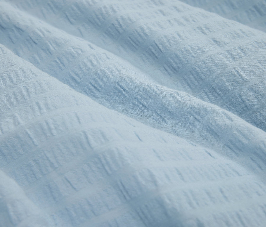 Gros plan d'un tissu bleu clair texturé.