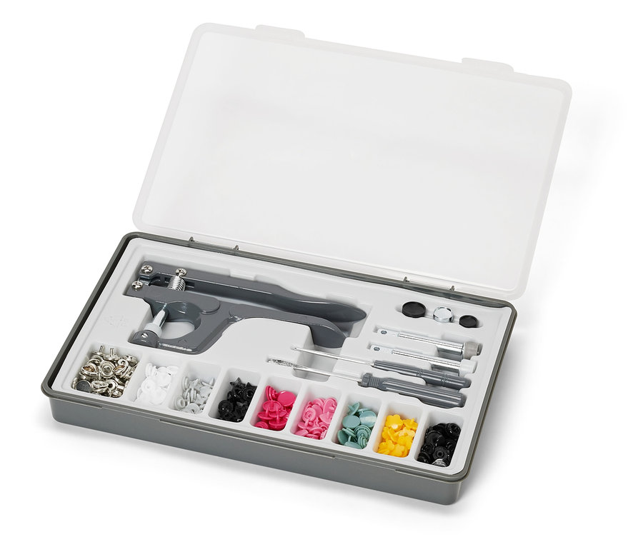 Boîte grise ouverte avec couvercle transparent contenant un ensemble de boutons-pression.