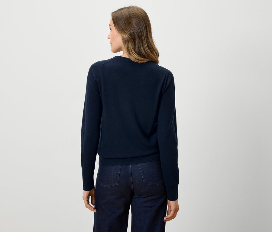 Vue arrière d'une femme portant un pull bleu marine et un jean foncé.