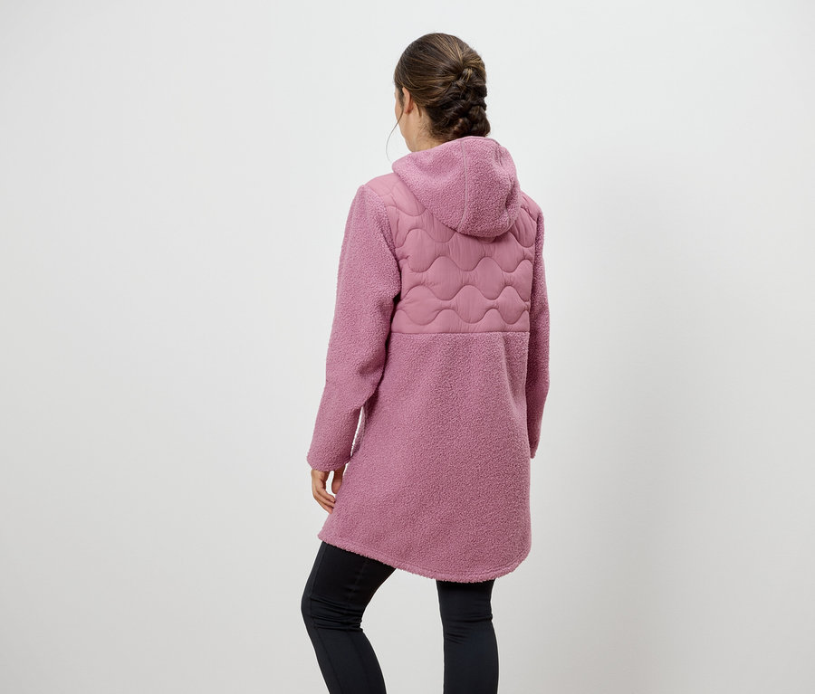 Une femme, vue de dos, porte un manteau rose à capuche et des leggings noirs.