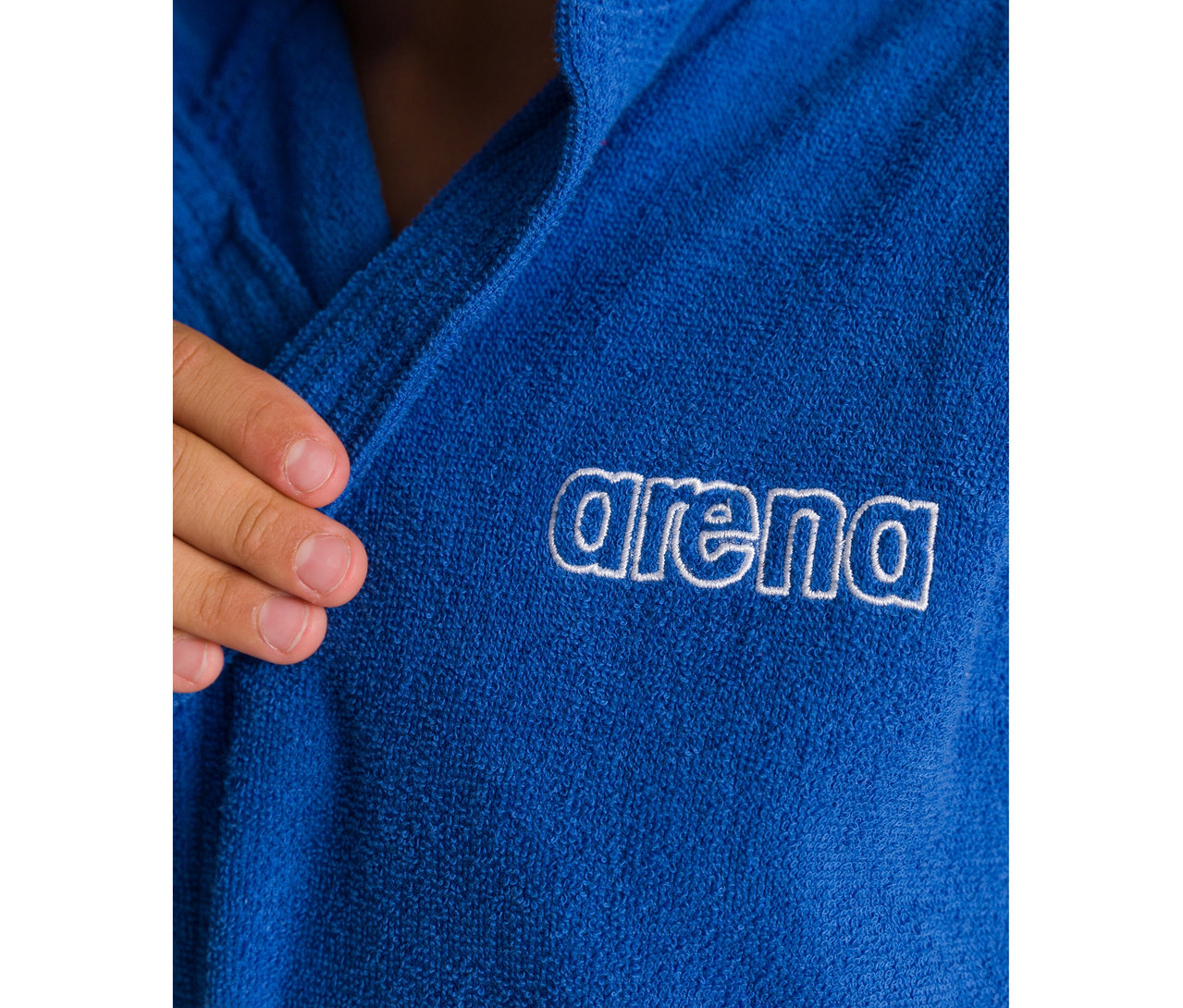 Gros plan d'un Peignoir pour enfant arena Zeppelin Light JR bleu avec logo blanc, tenu par une main.