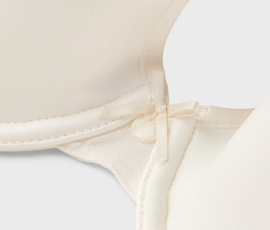Vue détaillée d'un soutien-gorge crème avec un nœud.