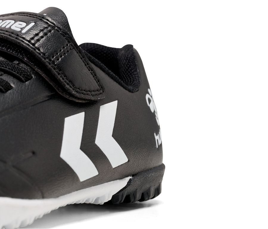 Gros plan d'une chaussure Hummel noire avec un logo blanc et une fermeture velcro.