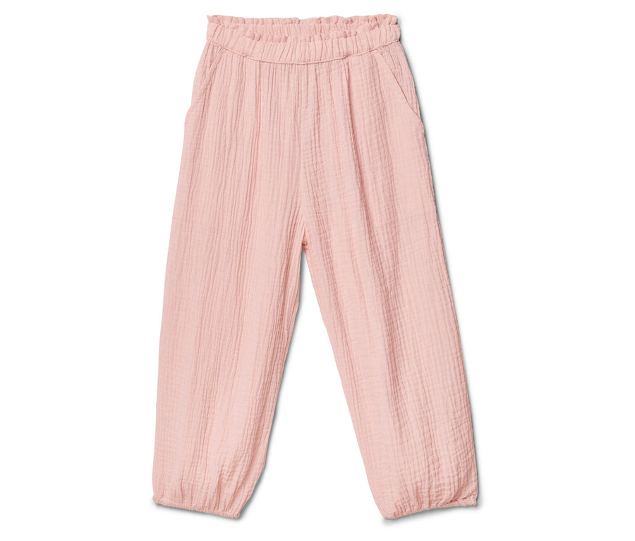 Un pantalon rose en tissu avec une taille élastique et des jambes bouffantes est posé sur un fond blanc.