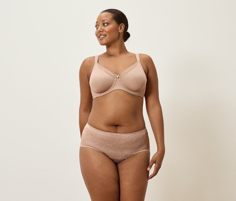 Femme portant un soutien-gorge couleur chair et une culotte en dentelle.