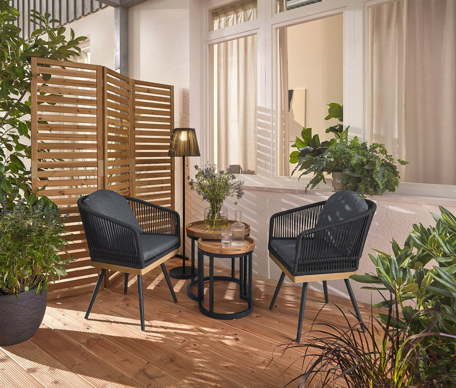 Deux chaises de jardin pivotantes avec tressage textile sont posées sur une terrasse en bois, entre elles deux tables d'appoint de jardin avec plateaux amovibles, Ø env. 40 cm et 50 cm. À l'arrière-plan, un paravent flexible et un lampadaire solaire à batterie.