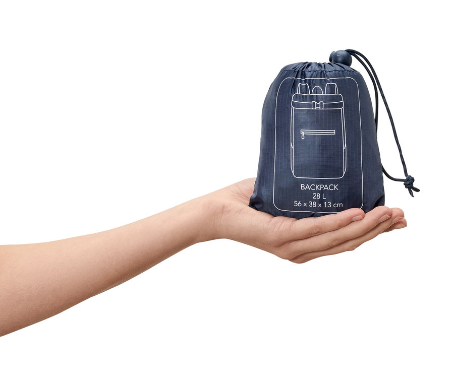 Une main tient un sac à dos bleu marine de 28 litres emballé avec un dessin de sac à dos blanc dessus.