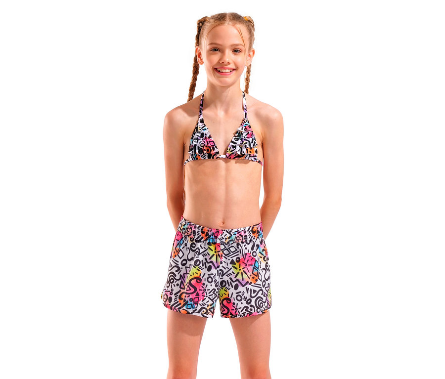 Fillette souriante avec des tresses portant un haut de bikini triangle à motifs colorés et un short.