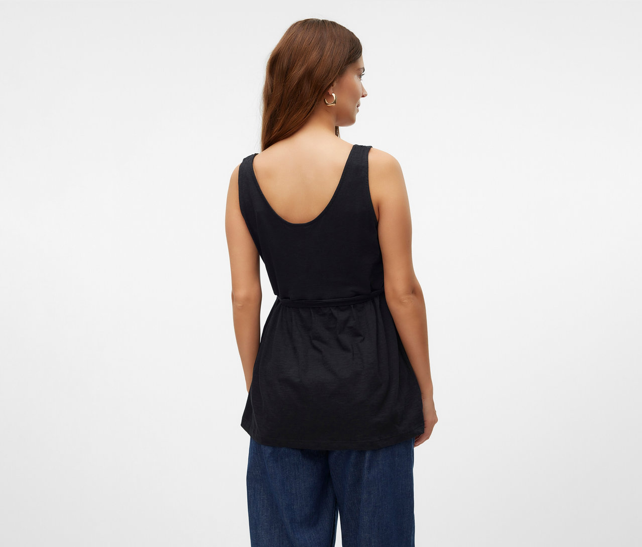 Femme vue de dos portant un top d’allaitement MAMALICIOUS «
MLEVI LIA » et un jean bleu.