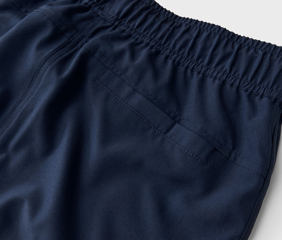 Gros plan sur un pantalon bleu marine avec une taille élastique et une poche arrière.