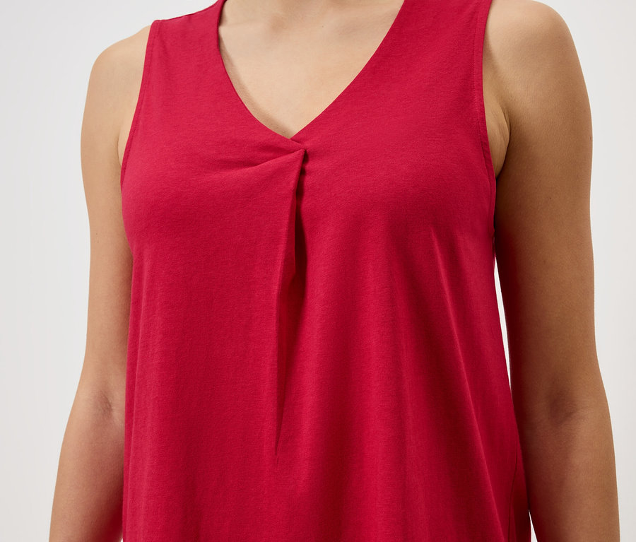 Gros plan d'une femme portant un débardeur rouge à col en V.