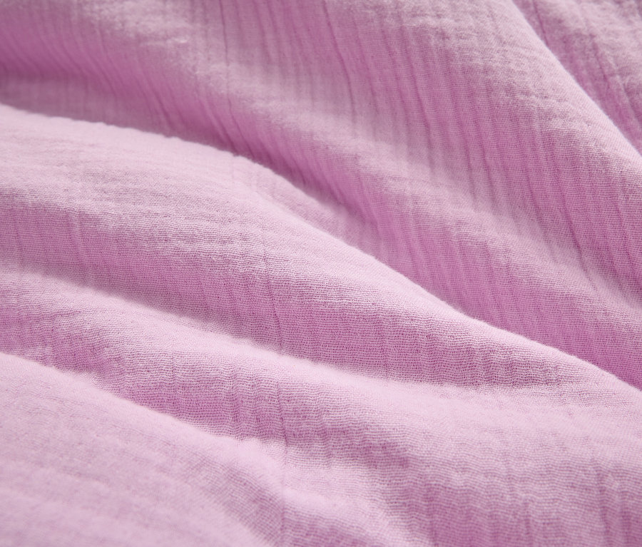 Gros plan d'un tissu froissé lilas clair.
