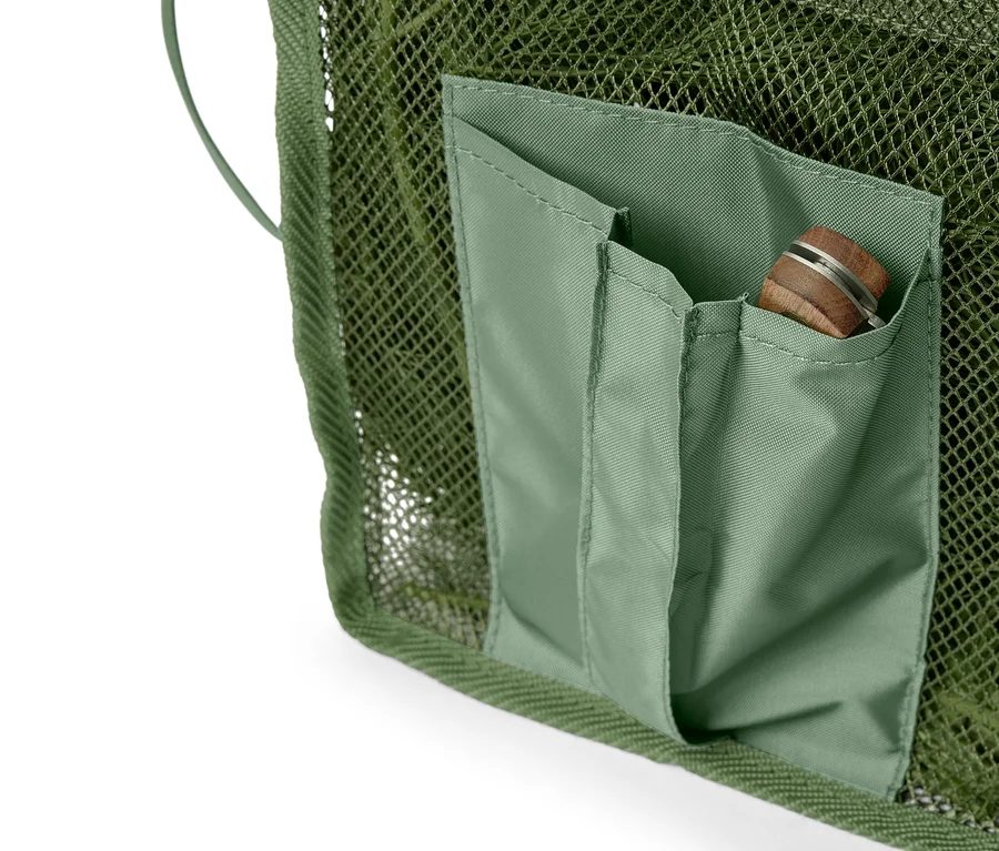 Gros plan d'un filet vert olive avec une poche cousue contenant un couteau de poche.