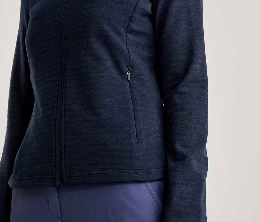 Gros plan d'une femme portant une veste zippée bleu marine et un pantalon bleu marine.