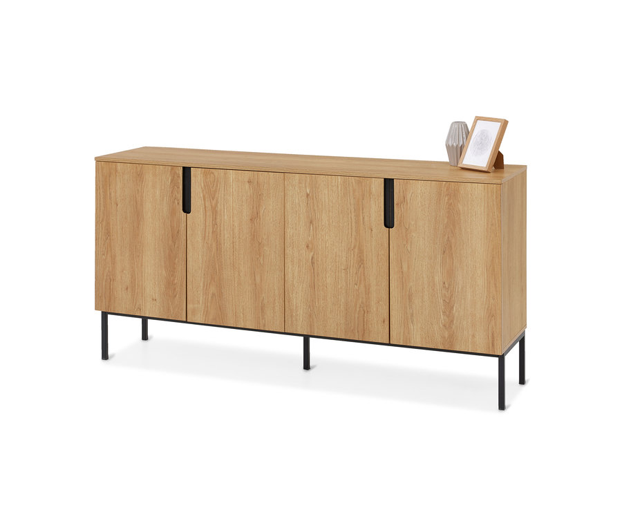 Buffet clair effet bois avec quatre portes et poignées noires, sur des pieds en métal noir. Dessus, un vase gris et un cadre photo en bois.