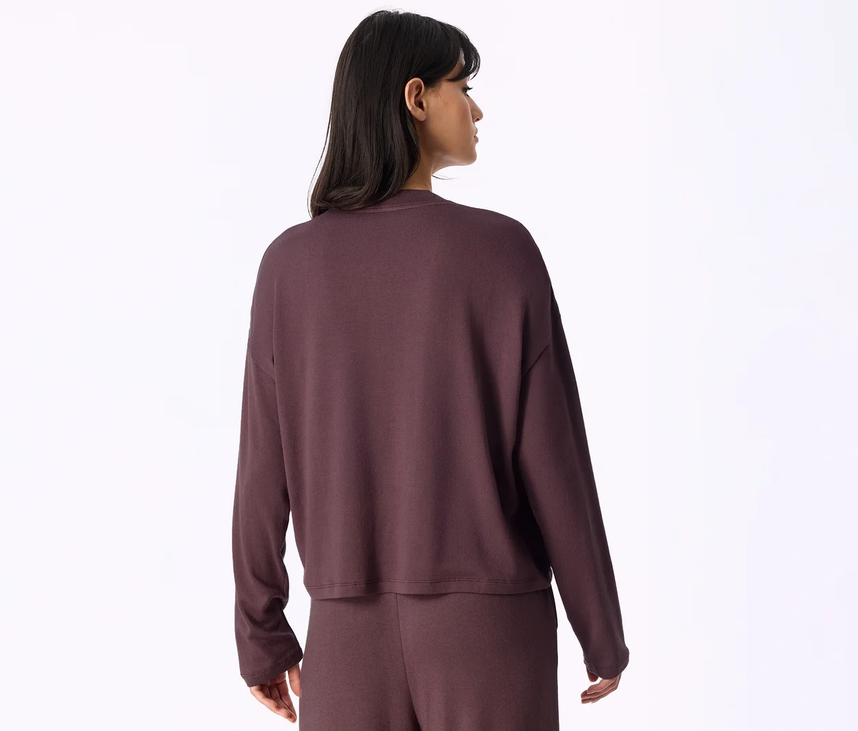Femme vue de dos, portant un haut à manches longues et un pantalon assorti de couleur violet foncé.