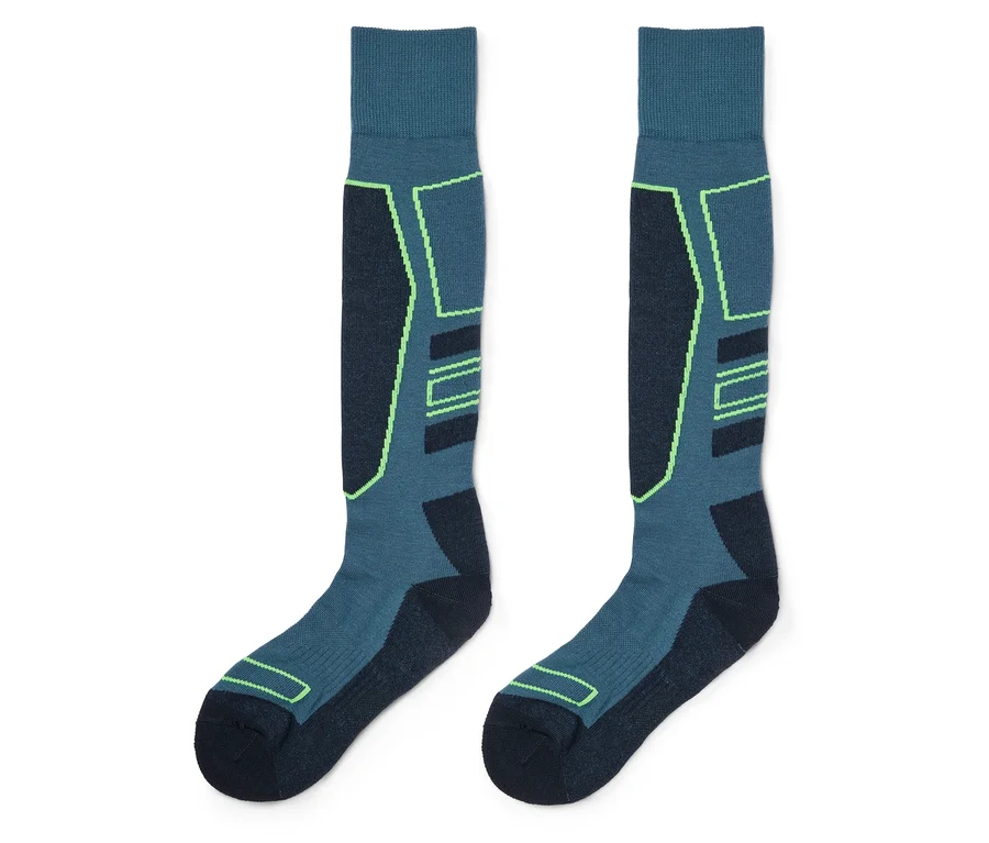 Une paire de chaussettes montantes bleu sarcelle et bleu foncé avec des accents vert fluo, sur fond blanc.
