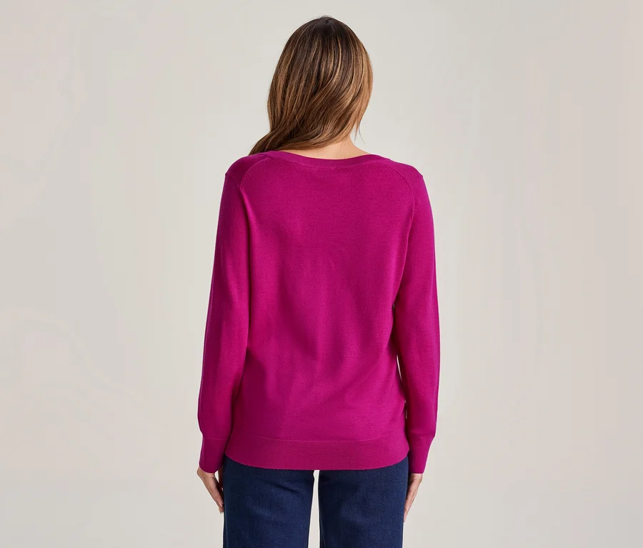 Femme vue de dos, portant un haut à manches longues magenta et un jean bleu foncé.