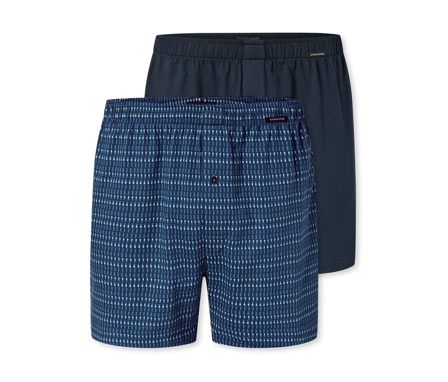 Deux boxers pour hommes, un bleu à rayures bleu clair et un bleu marine, posés l'un sur l'autre.