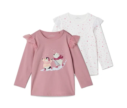 Deux t-shirts à manches longues pour enfants : un rose avec un pingouin et un ours polaire patinant, et un blanc avec un motif d'étoiles roses, tous deux avec des volants aux épaules.