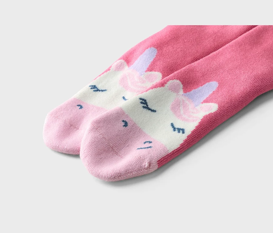 Gros plan de deux chaussettes roses avec un motif de licorne.
