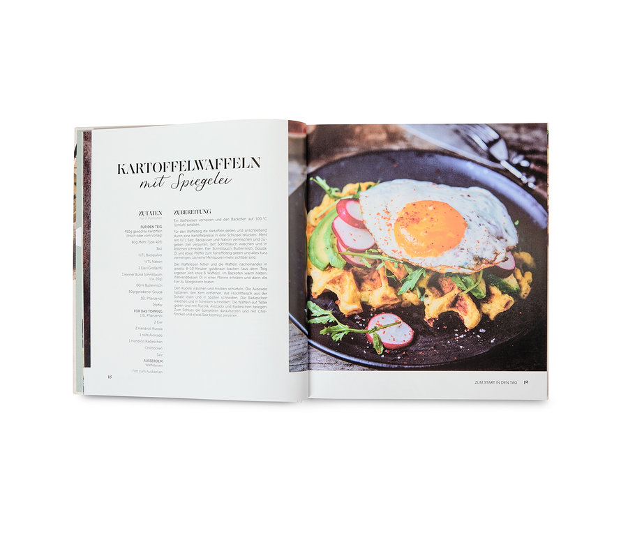 Un livre de cuisine ouvert présentant une recette de gaufres de pommes de terre avec un œuf au plat.