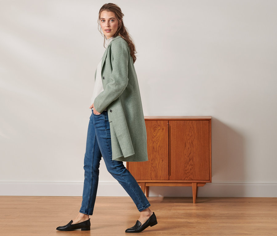 Femme marchant et portant un manteau court avec de la laine.