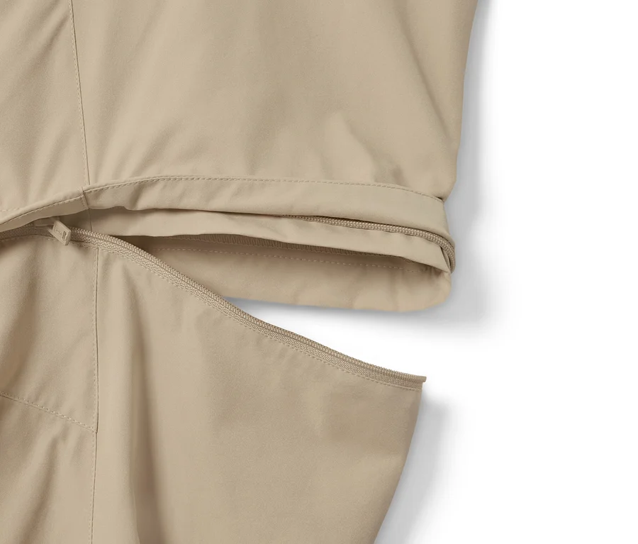 Détail d'un pantalon fonctionnel 2 en 1 beige avec fermeture éclair.
