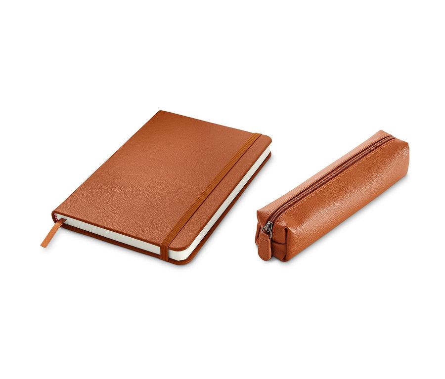Un carnet de notes et une trousse à crayons marron sont posés sur un fond blanc.