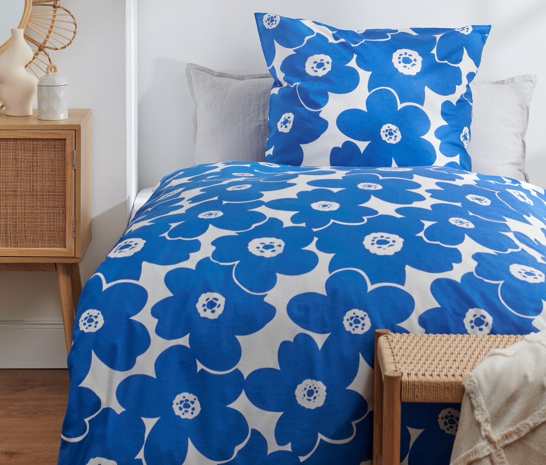 Parure de lit en coton bleu de qualité supérieure, taille standard et grande taille, sur un lit.