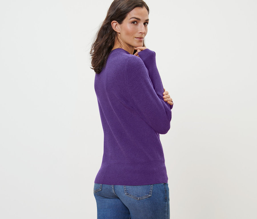 Femme posant dans un pull en maille fine.