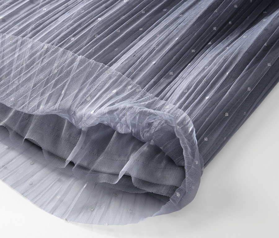 Gros plan sur une jupe en tulle plissée avec un dégradé de couleurs.