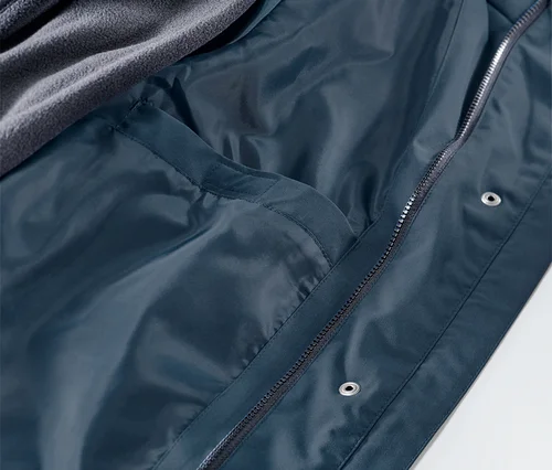 Détail d'une veste de pluie 3 en 1, intérieur avec poche et couche polaire grise.