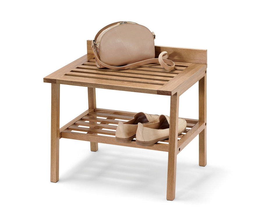 Un sac à main est posé sur l'étagère supérieure d'un tabouret avec de larges surfaces de rangement, et des chaussures sont posées en dessous.