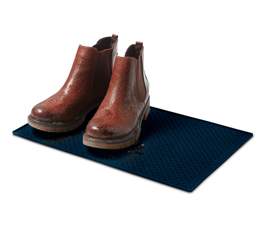 Deux bottes en cuir marron sont posées sur un dessous de gamelle bleu.